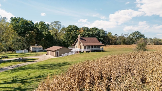 view of side of property with an outbuilding, a lawn, a detached garage, and a chimney