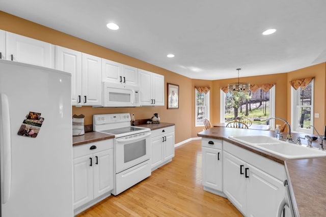 9100 Boggie Dr Unit 159, Canadian Lakes, MI 49346 - kitchen featuring white appliances, a sink, a chandelier, light wood-style floors, and white cabinetry