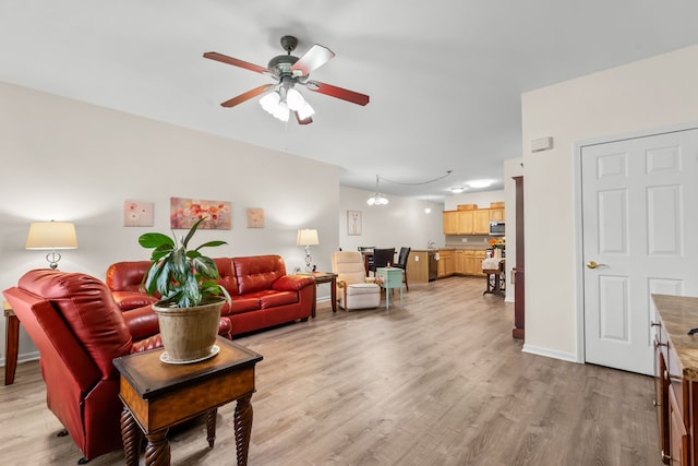 living room featuring light wood finished floors, a ceiling fan, and baseboards