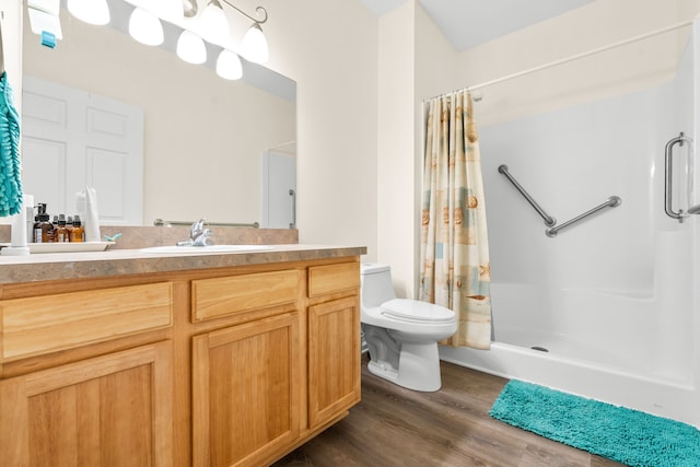 bathroom featuring a shower stall, wood finished floors, toilet, and vanity