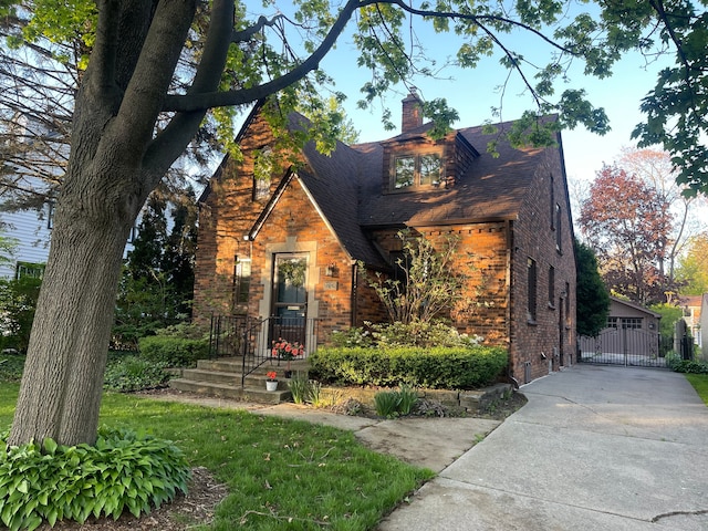 532 Saint Clair St, Grosse Pointe, MI 48230 - english style home featuring brick siding, a chimney, and concrete driveway