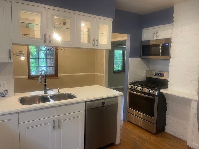 532 Saint Clair St, Grosse Pointe, MI 48230 - kitchen with stainless steel appliances, a sink, white cabinets, light countertops, and dark wood-style floors