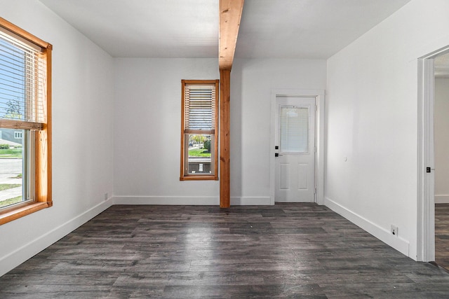 601 N Rath Ave, Ludington, MI 49431 - spare room featuring dark wood-style floors, baseboards, and beamed ceiling