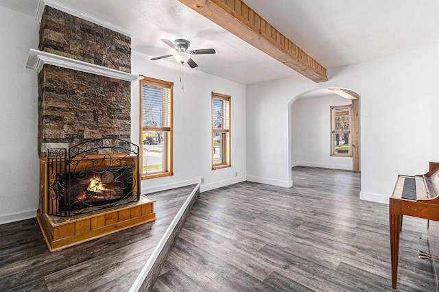 601 N Rath Ave, Ludington, MI 49431 - unfurnished living room with arched walkways, a ceiling fan, wood finished floors, beamed ceiling, and baseboards