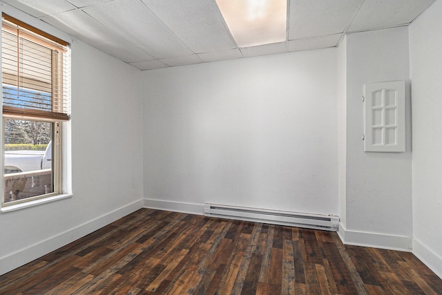 601 N Rath Ave, Ludington, MI 49431 - spare room featuring a baseboard heating unit, dark wood-type flooring, baseboards, and a drop ceiling