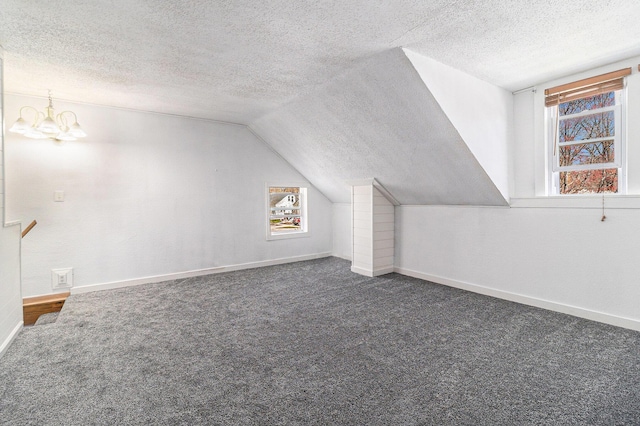 601 N Rath Ave, Ludington, MI 49431 - bonus room with carpet, a textured ceiling, baseboards, lofted ceiling, and a chandelier