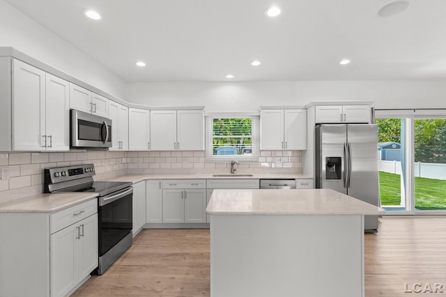 4189 Evergreen Rd, Adrian, MI 49221 - kitchen with stainless steel appliances, a sink, light wood-style flooring, a kitchen island, and white cabinetry