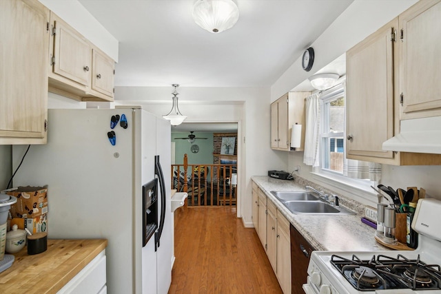 kitchen with white appliances, a sink, under cabinet range hood, and light countertops
