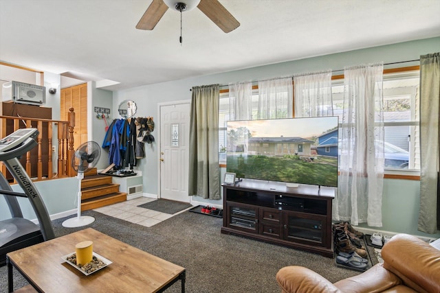 living room featuring plenty of natural light, stairway, ceiling fan, and baseboards