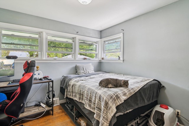 bedroom with wood finished floors, a desk, and baseboards