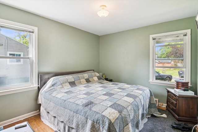 bedroom with baseboards and wood finished floors