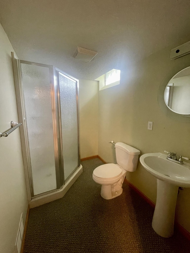 full bathroom with a stall shower, toilet, baseboards, and a sink