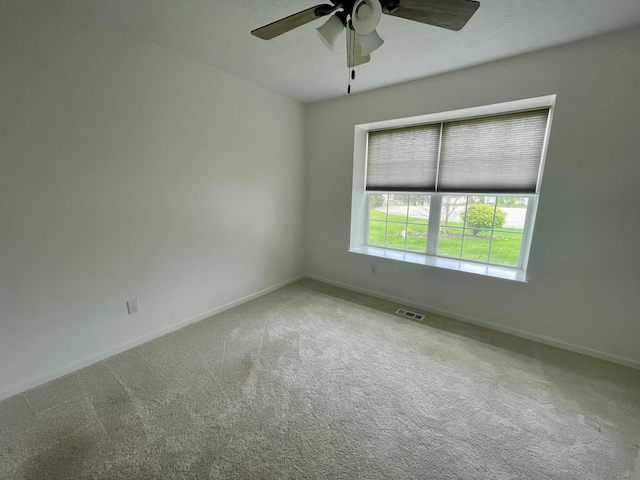 empty room featuring carpet floors, ceiling fan, and baseboards