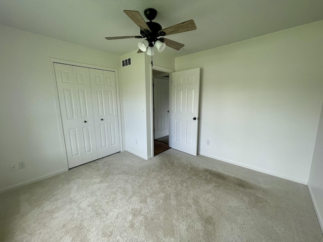 unfurnished bedroom with carpet, baseboards, a closet, and a ceiling fan