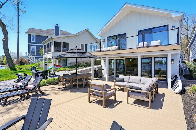 rear view of house featuring a balcony, outdoor lounge area, outdoor dining space, and a deck