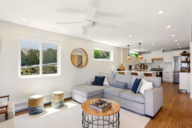 living area with recessed lighting, light wood-style floors, and ceiling fan