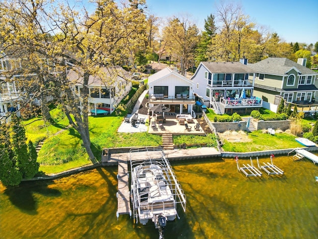 back of house with a water view, boat lift, and stairs