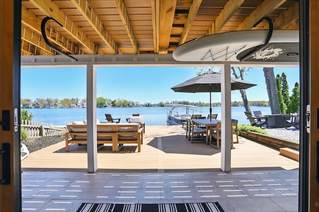 view of patio featuring a water view, outdoor dining space, and an outdoor living space