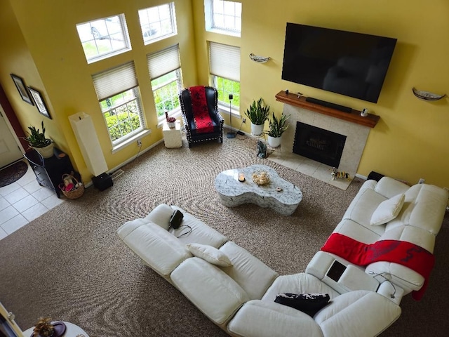 24864 Christina Dr, Flat Rock, MI 48134 - living area with a fireplace, healthy amount of natural light, tile patterned flooring, a towering ceiling, and baseboards