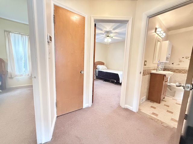 corridor with light colored carpet and tile walls
