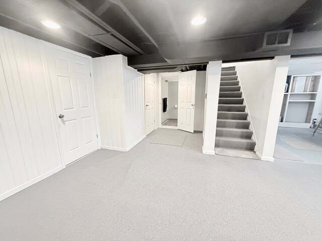 finished basement with stairs, recessed lighting, and baseboards