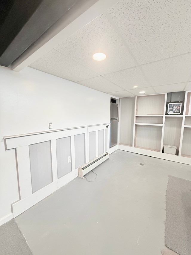 finished basement with a baseboard heating unit, recessed lighting, and a drop ceiling