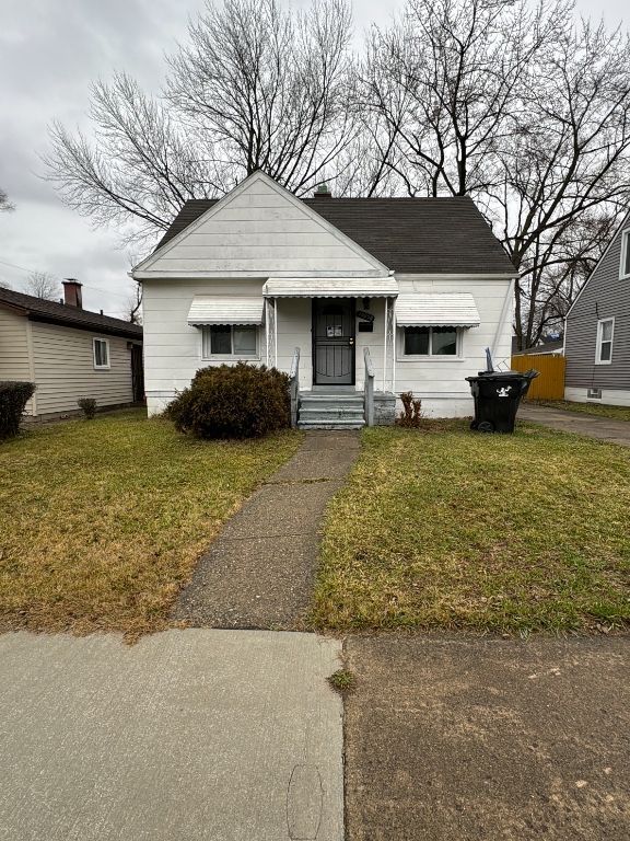 bungalow-style house featuring a front lawn