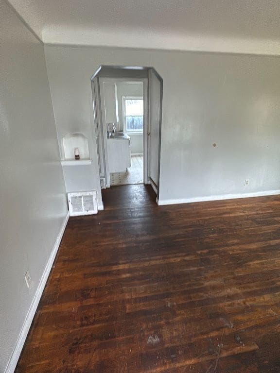 empty room featuring wood finished floors and baseboards