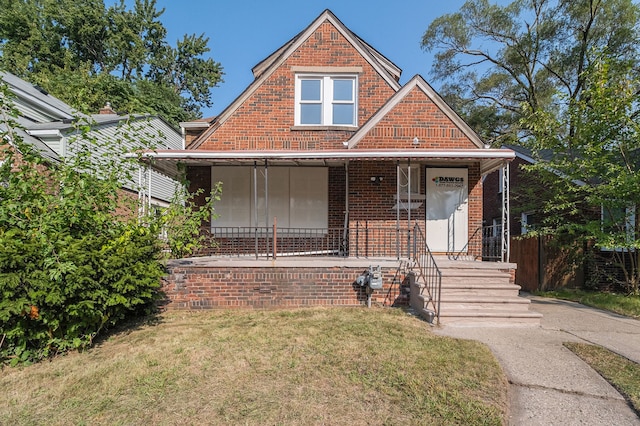 20410 Hull St, Highland Park, MI 48203 - view of front facade with covered porch, a front lawn, and brick siding