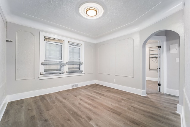 20410 Hull St, Highland Park, MI 48203 - unfurnished room with arched walkways, wood finished floors, a textured ceiling, and baseboards