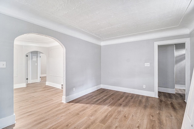 20410 Hull St, Highland Park, MI 48203 - empty room with wood finished floors, baseboards, arched walkways, and a textured ceiling
