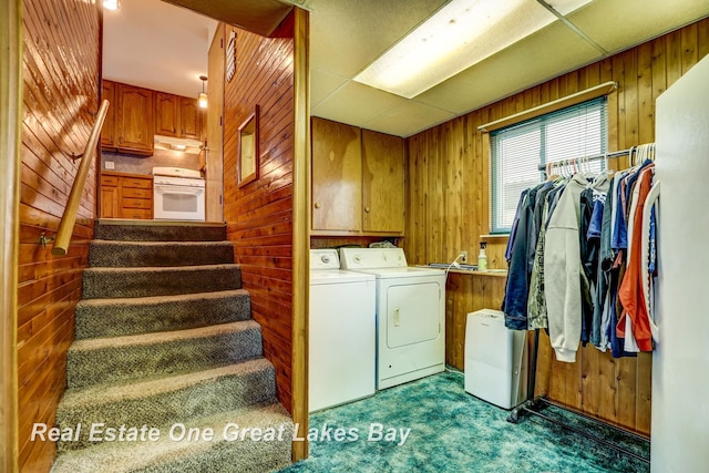 2505 Blake St, Saginaw, MI 48602 - clothes washing area featuring independent washer and dryer, cabinet space, wooden walls, and dark carpet