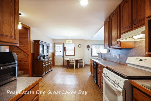 2505 Blake St, Saginaw, MI 48602 - kitchen featuring white gas stove, under cabinet range hood, black dishwasher, and healthy amount of natural light