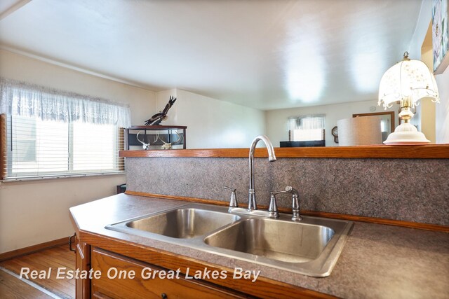 2505 Blake St, Saginaw, MI 48602 - kitchen featuring a sink, wood finished floors, and baseboards