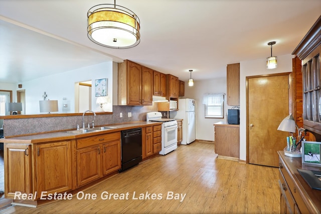 2505 Blake St, Saginaw, MI 48602 - kitchen featuring white appliances, a sink, brown cabinets, and light wood finished floors