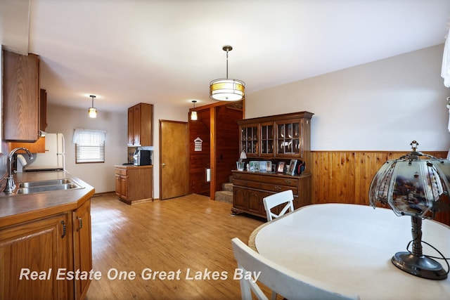 2505 Blake St, Saginaw, MI 48602 - dining area with wood walls, light wood-style floors, and a wainscoted wall