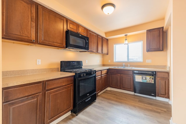 4770 Matthew St, Westland, MI 48186 - kitchen featuring black appliances, a sink, light wood-style flooring, light countertops, and brown cabinetry
