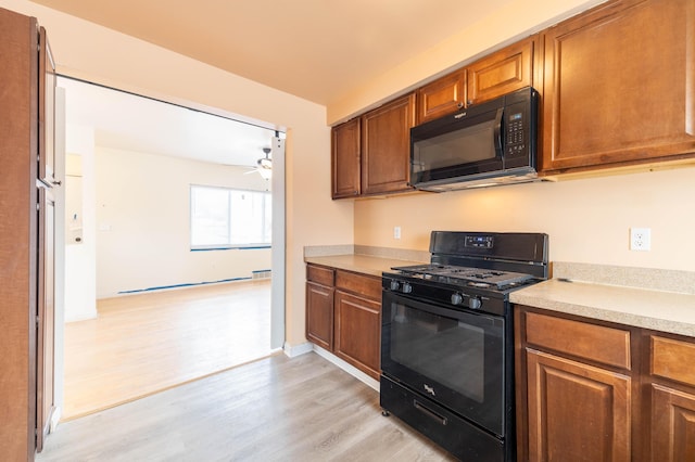 4770 Matthew St, Westland, MI 48186 - kitchen with black appliances, light wood-style floors, light countertops, and brown cabinetry