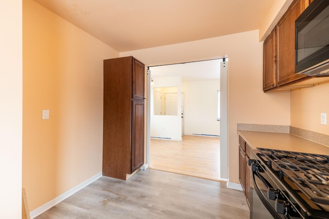 4770 Matthew St, Westland, MI 48186 - kitchen featuring black appliances, light wood-style floors, brown cabinetry, light countertops, and baseboards