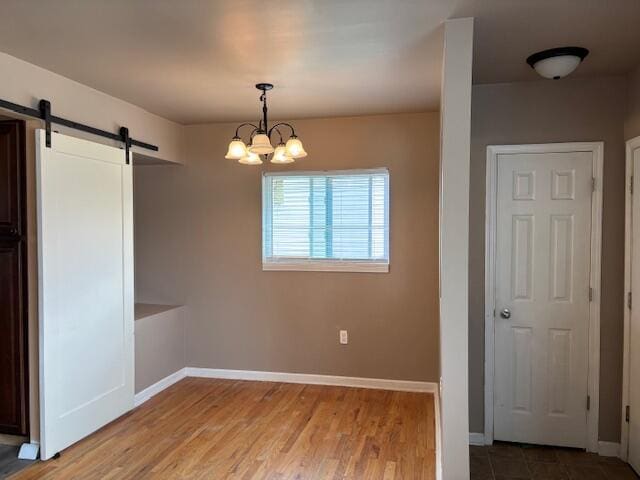 4770 Matthew St, Westland, MI 48186 - unfurnished dining area with a barn door, a chandelier, baseboards, and wood finished floors
