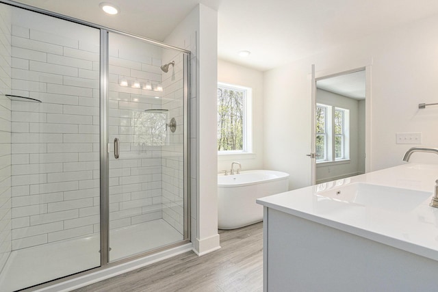 15250 Alister Mackenzie Ave, Augusta, MI 49012 - full bathroom featuring a stall shower, wood finished floors, a soaking tub, double vanity, and recessed lighting