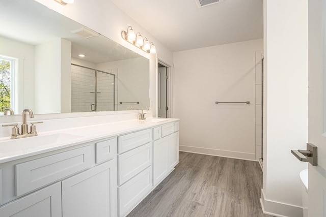 15250 Alister Mackenzie Ave, Augusta, MI 49012 - bathroom with a stall shower, wood finished floors, double vanity, and baseboards