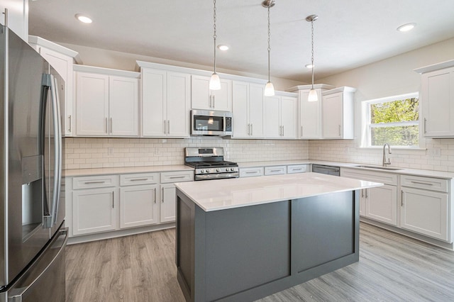 15250 Alister Mackenzie Ave, Augusta, MI 49012 - kitchen with appliances with stainless steel finishes, a sink, light wood-style flooring, light countertops, and white cabinetry