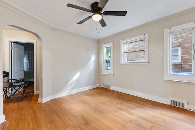 14028 Whitcomb St, Detroit, MI 48227 - spare room featuring light wood-style flooring, crown molding, baseboards, arched walkways, and ceiling fan
