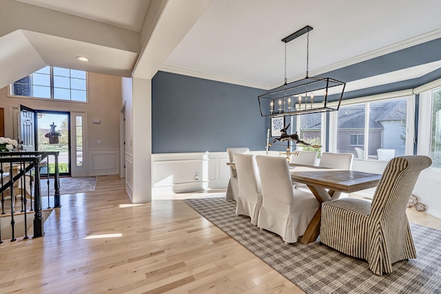 26930 Victory Ct, South Lyon, MI 48178 - dining area with a decorative wall, light wood-style floors, a chandelier, a wainscoted wall, and ornamental molding