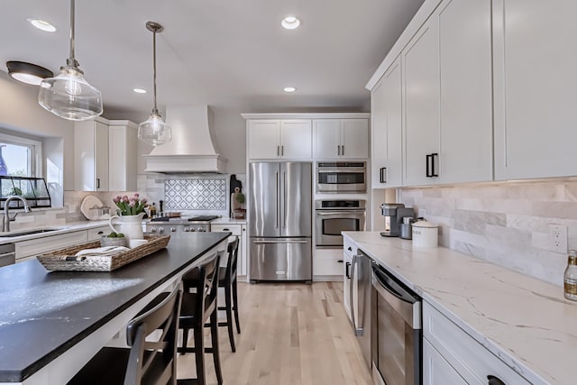 26930 Victory Ct, South Lyon, MI 48178 - kitchen featuring freestanding refrigerator, custom exhaust hood, a sink, recessed lighting, and white cabinets