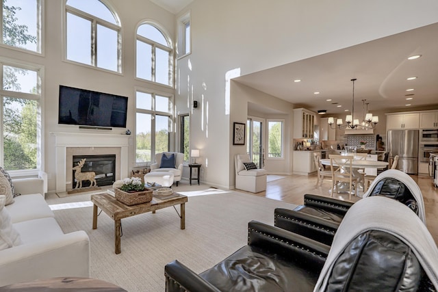 26930 Victory Ct, South Lyon, MI 48178 - living area with healthy amount of natural light, a high end fireplace, a chandelier, recessed lighting, and a high ceiling