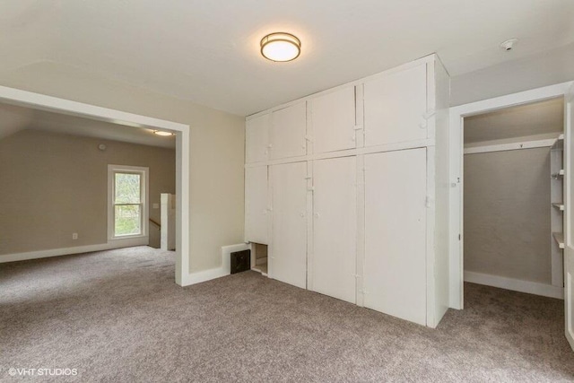 unfurnished bedroom with light colored carpet, a closet, and baseboards