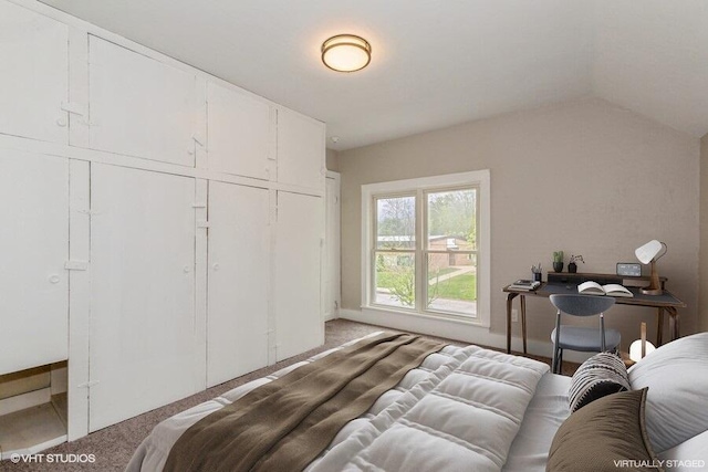 bedroom featuring light colored carpet, a closet, vaulted ceiling, and baseboards