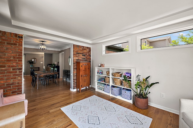living area featuring baseboards, healthy amount of natural light, and wood finished floors